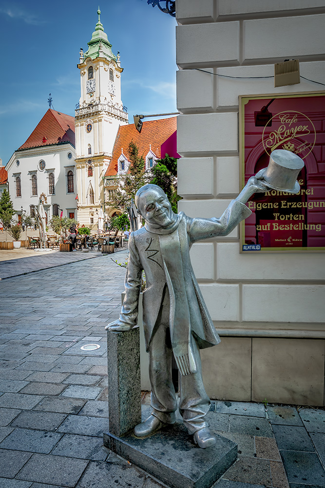 Escultura de hombre saludando con una chistera en una plaza de Bratislava
