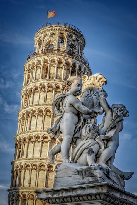 Torre de Pisa con una escultura de mármol delante
