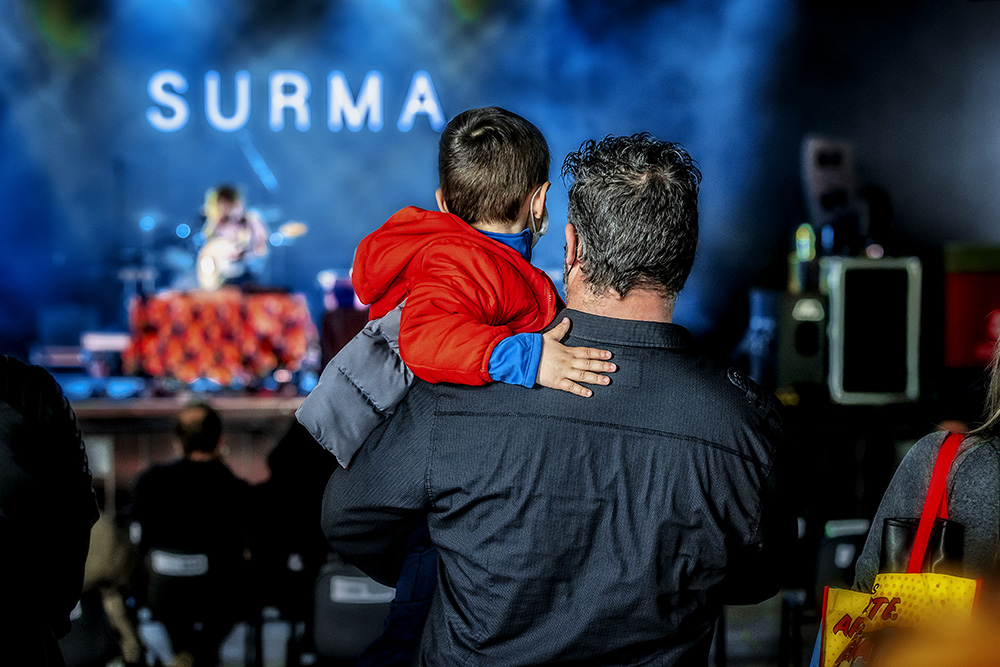 Padre con un niño en brazos viendo un concierto