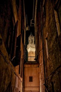 El campanario de la torre de Siena vista desde una callejuela